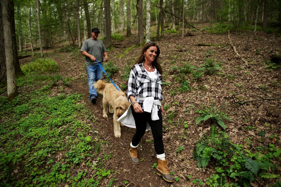 Couple walking through woods with dog